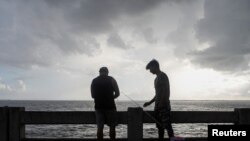  Alex Rodríguez y su primo Javier Rodríguez pescan desde el muelle del puente North Skyway mientras nubes oscuras se ciernen sobre el canal de la Bahía de Tampa antes de la tormenta tropical Elsa, en St. Petersburg, Florida, el 5 de julio de 2021. REUTERS