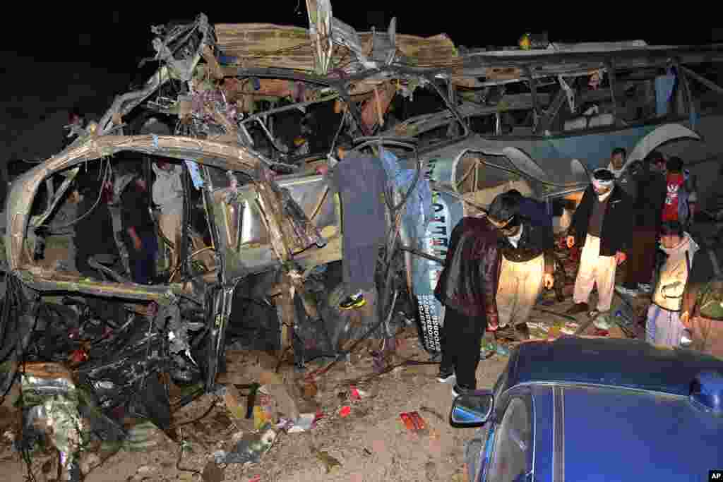 People look at the wreckage of a passenger bus destroyed in a bomb blast in the Mastong district, near Quetta, Jan. 21, 2014.