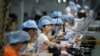 资料照：中国深圳一家工厂的工人在生产线上制造吸尘器。（2019年8月9日）