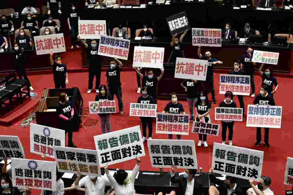 Taiwan’s main opposition Kuomintang legislators display placards that read "keep the Procedural Justice" as they protest calling for the government to apologize for coronavirus deaths, at the Parliament in Taipei.