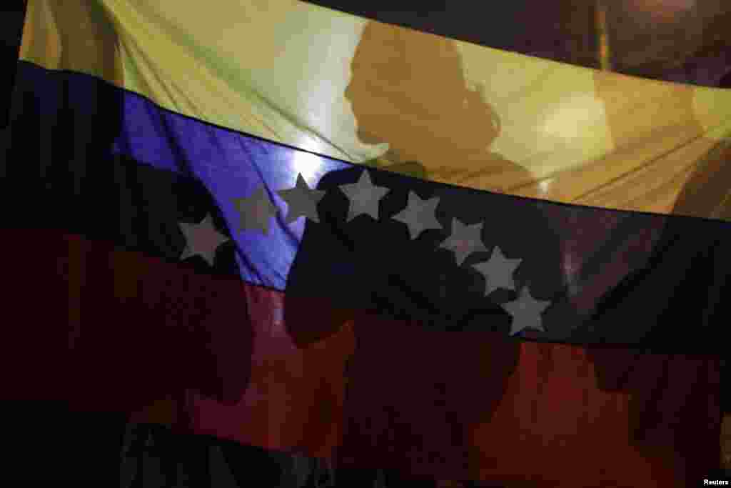 Shadows are cast on a Venezuelan national flag during a protest supporting Venezuelan opposition leader Henrique Capriles in Panama City April 15, 2013. 