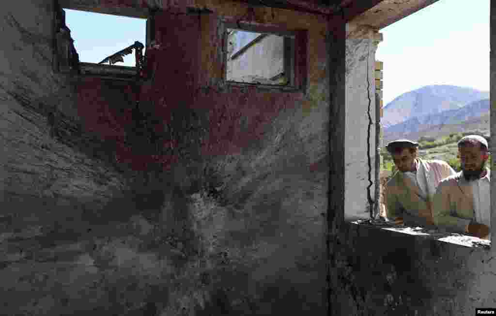 Afghan men look at the entrance of a government building after an attack by insurgents, Panjshir, Afghanistan, May 29, 2013.