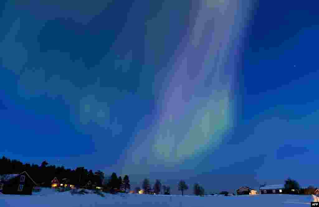 'Aurora borealis' tampak menerangi langit saat senja antara kota Are dan Östersund di Swedia.