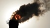 The sun is seen behind smoke billowing from a chimney of a heating plant in Taiyuan, Shanxi province December 9, 2013.