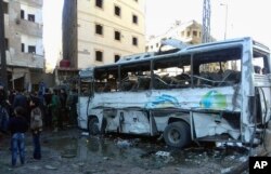 FILE - In this photo released by the Syrian official news agency SANA, Syrians gather where three bombs exploded in Sayyda Zeinab, a predominantly Shiite Muslim suburb of the Syrian capital, Syria, Jan. 31, 2016.