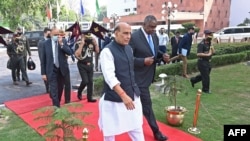 Indian Defense Minister Rajnath Singh walks with visiting U.S. Defense Secretary Lloyd Austin before reviewing an honor guard in New Delhi, March 20, 2021.