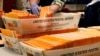 FILE - Election officials sort absentee and early voting ballots for counting inside Boston City Hall in Boston, Nov. 2, 2020.