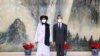 In this photo released by China's Xinhua News Agency, Taliban co-founder Mullah Abdul Ghani Baradar, left, and Chinese Foreign Minister Wang Yi pose for a photo during their meeting in Tianjin, China, July 28, 2021.