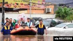 A rescue team evacuates locals on an inflatable boat during a flood after heavy rain in Bekasi, near Jakarta, Indonesia, Jan. 1 2020. (Antara Foto/Saptono/via Reuters)