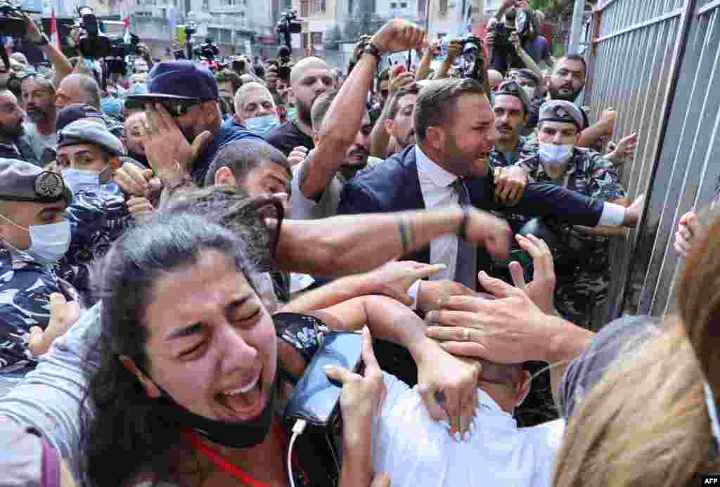 Activists and relatives of victims of the Beirut port explosion scuffle among themselves as Lebanese security members try to interfere during a demonstration outside the capital's Justice Palace, to protest the suspension of the investigation into the August 4, 2020, port explosion.