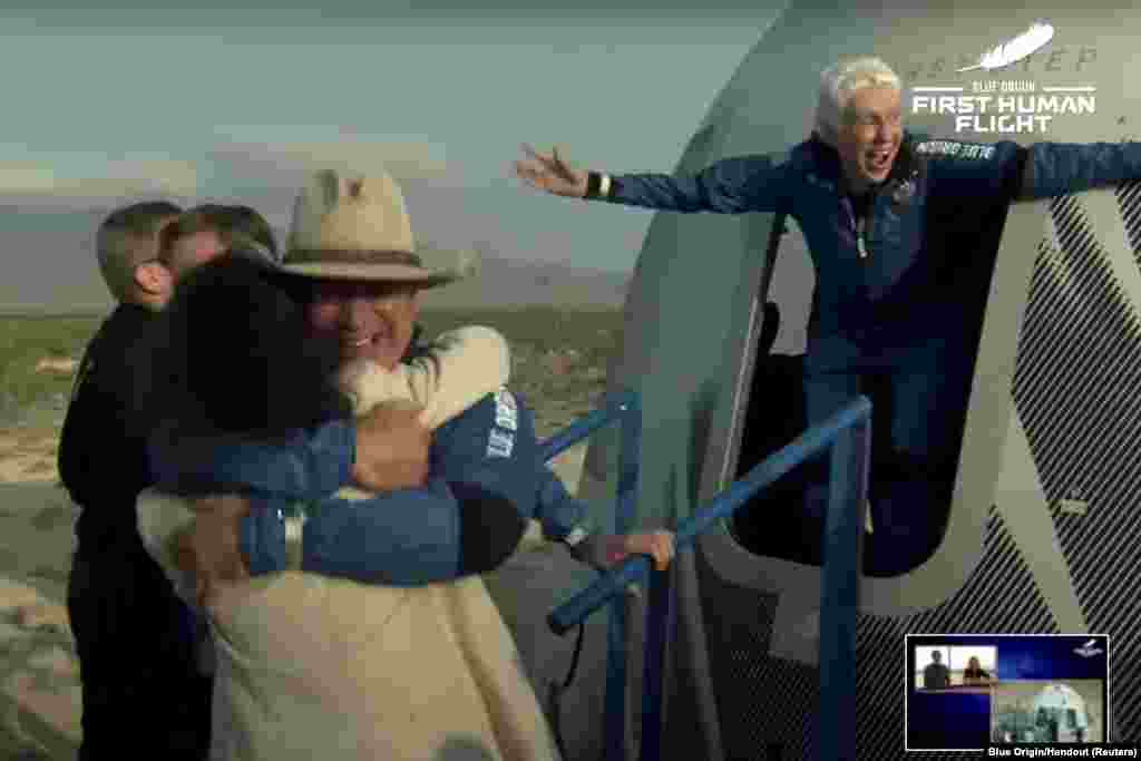Billionaire Jeff Bezos and pioneering female aviator Wally Funk emerge from Blue Origin's New Shepard rocket after returning from the world's first unpiloted suborbital flight near Van Horn, Texas.
