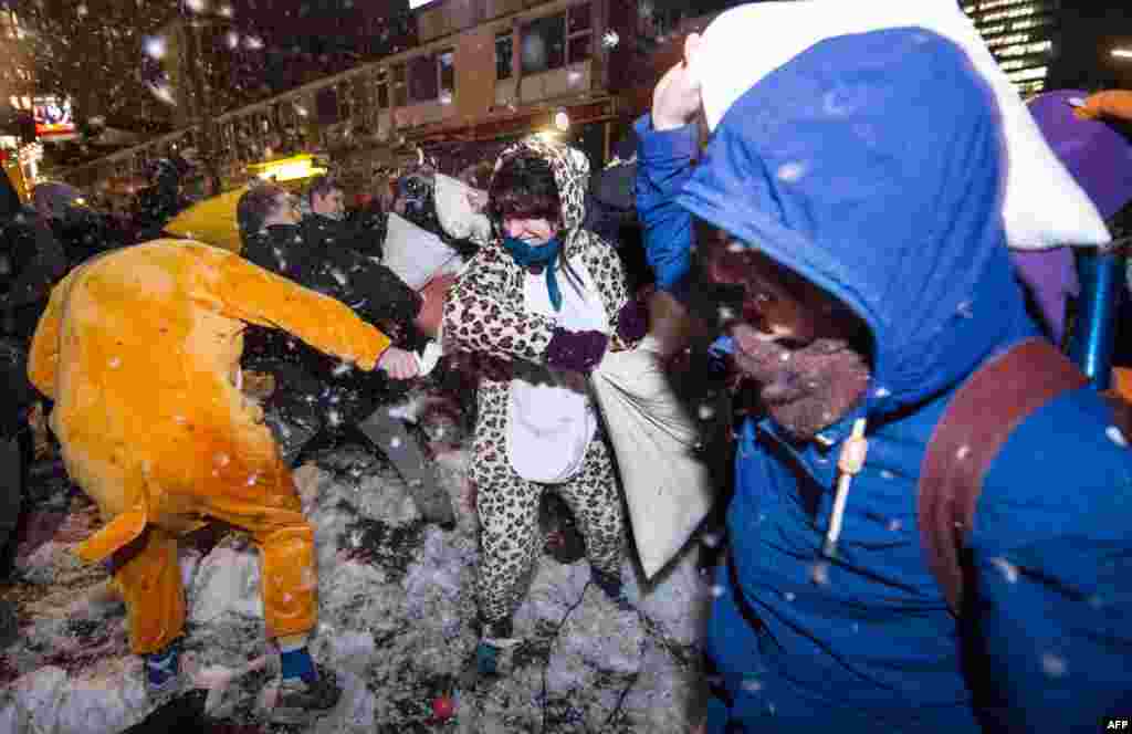 Participants of a flashmob throw pillows and feathers on the Reeperbahn in Hamburg, Germany. A few hundred people took part in the pillow fight to protest against the "danger zone" set up by the police.