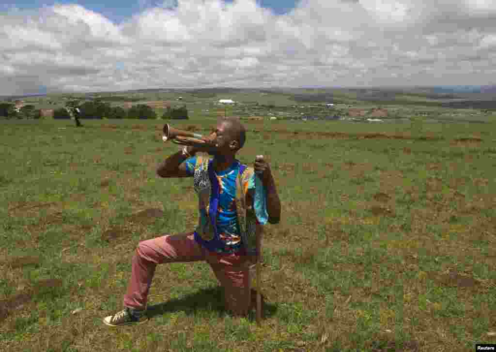 Seorang pria Zulu memainkan terompet setelah pemakaman mantan presiden Afrika Selatan Nelson Mandela di Qunu, Afrika Selatan, 15 Desember 2013.