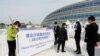 2021年10月8日，在中国国家速滑馆举行的冬奥会测试赛门外，工作人员引导人们出示新冠核酸检测结果。