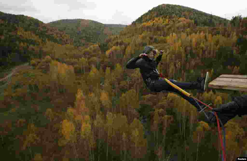 Seorang perempuan melompat "bungee" dari ketinggian 44-meter di dekat sebuah jembatan di kota Taiga, Siberia, Rusia.