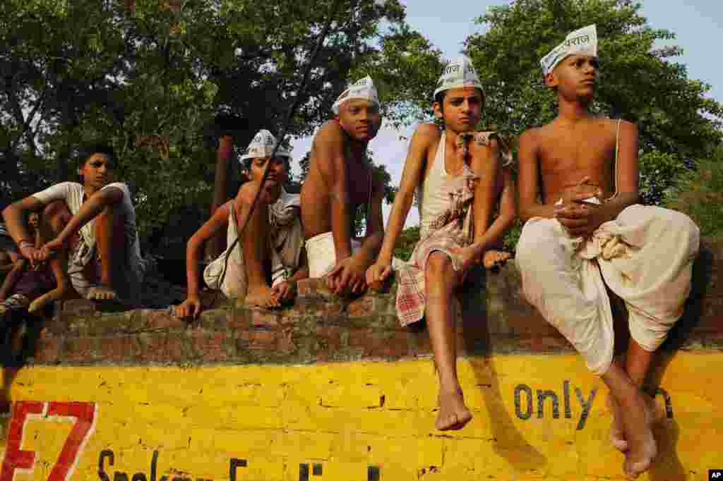 Para siswa remaja penganut Hindu memakai Aam Aadmi Party (AAP), atau Partai Rakyat, menunggu kedatangan pemimpin AAP Arvind Kejriwal dalam kampanye pemilihan di Varanasi, di negara bagian India utara, Uttar Pradesh. 