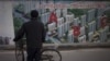2013年1月北京一处工地旁有人观看居民楼鸟瞰图。何清涟写道，中国房地产价格攀升与全国数百座鬼城同时出现。