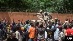 Waandamanaji wakishangilia wanajeshi wa Niger wakiwa wamekusanyika mbele ya Ubalozi wa Ufaransa mjini Niamey wakati wa maandamano yaliyofuatia maandamano ya kuunga mkono serikali ya Niger mjini Niamey Julai 30, 2023. AFP.