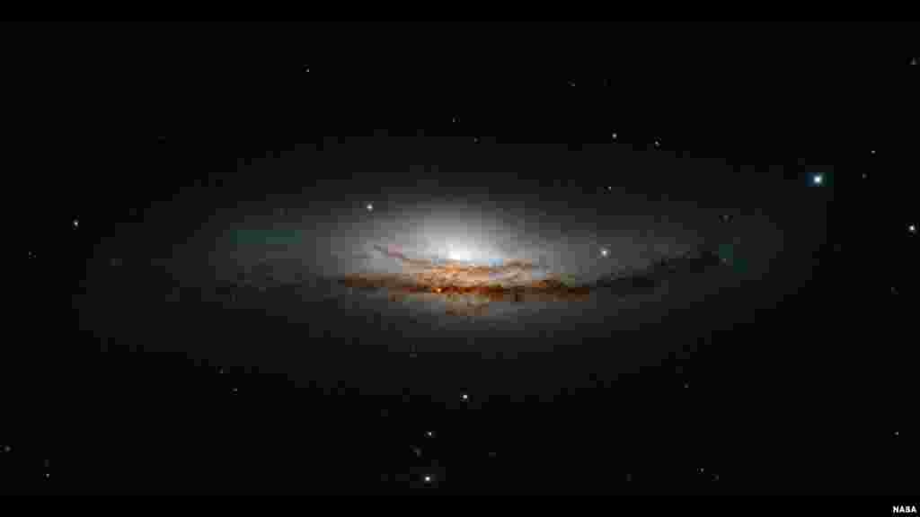 Gambar baru Hubble ini berpusat pada NGC 5793, galaksi spiral yang berjarak lebih dari150 juta tahun cahaya di rasi bintang Libra. Galaksi ini memiliki dua fitur mencolok: lintasan debu yang indah dan pusatnya yang sangat terang — lebih terang dari dari galaksi kita sendiri, atau dari kebanyakan galaksi spiral yang kita amati (Foto Kredit: NASA, ESA, dan E. Perlman (Institut Teknologi Florida).