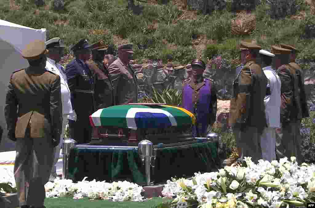 Foto diambil dari Perusahaan Penyiaran Afrika Selatan menunjukkan anggota tentara bersenjata Afrika Selatan berdiri dekat peti mati mantan presiden Afrika Selatan Nelson Mandela sebelum diturunkan ke liang kubur pada pemakamannya, 15 Desember 2013.