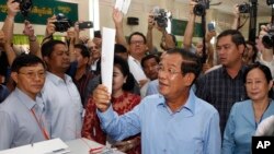 Perdana Menteri Kamboja Hun Se menunjukkan surat suaranya di TPS di Takhmua, provinsi Kandal, Phnom Penh tenggara, Kamboja, Minggu, 29 Juli 2018. 