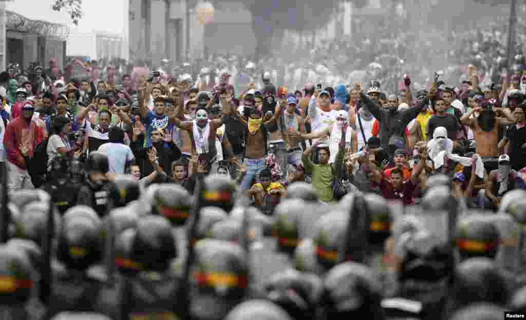 Supporters of opposition leader Henrique Capriles face off against riot police as they demonstrated for a recount of the votes in Sunday's election, in Caracas, April 15, 2013. 