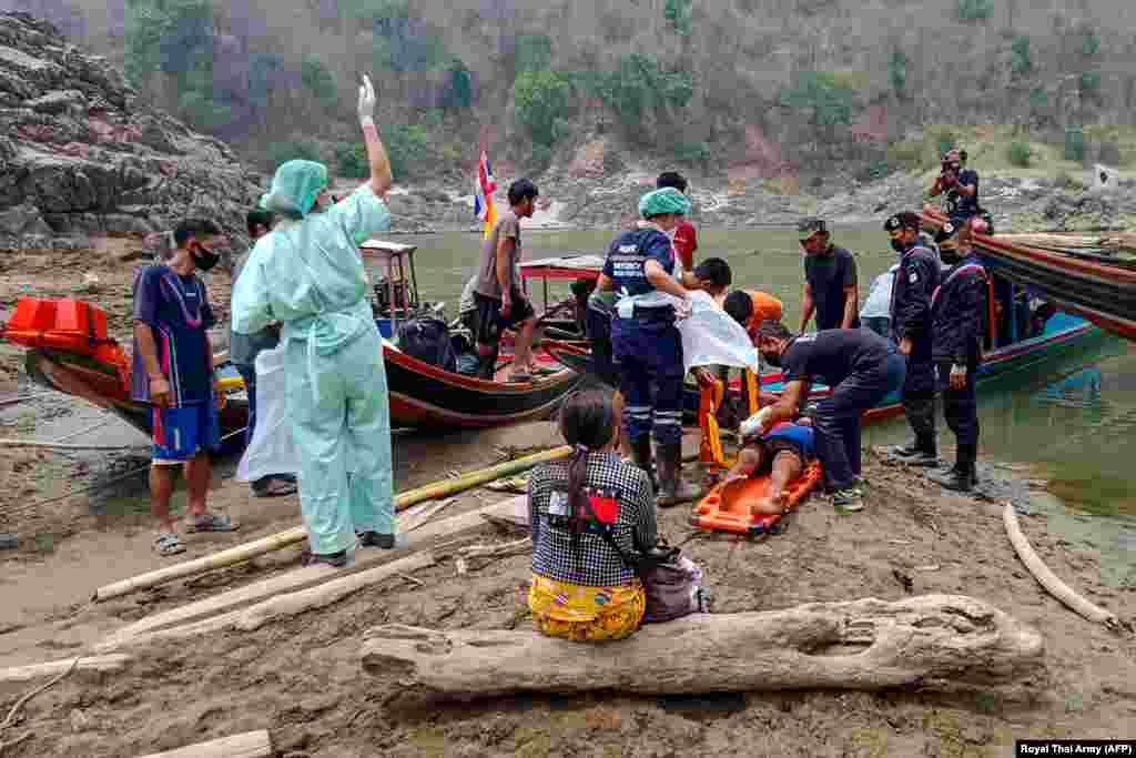 An injured Myanmar refugee is transported to a hospital in Mae Sam Lap, Thailand, after crossing the Salween river from the Myanmar side while while fleeing from airstrikes in Myanmar's eastern Karen state following the February military coup. 