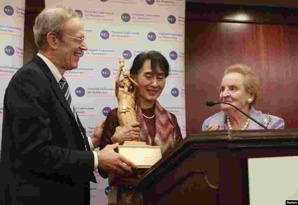 Bà Suu Kyi nhận giải của tổ chức phát huy dân chủ National Endowment for Democracy do ông Carl Gershman, Chủ tịch của tổ chức này trao tại Washington. Bên cạnh là bà Madeleine Albright, cựu ngoại trưởng Hoa Kỳ. 20/9/2012.
