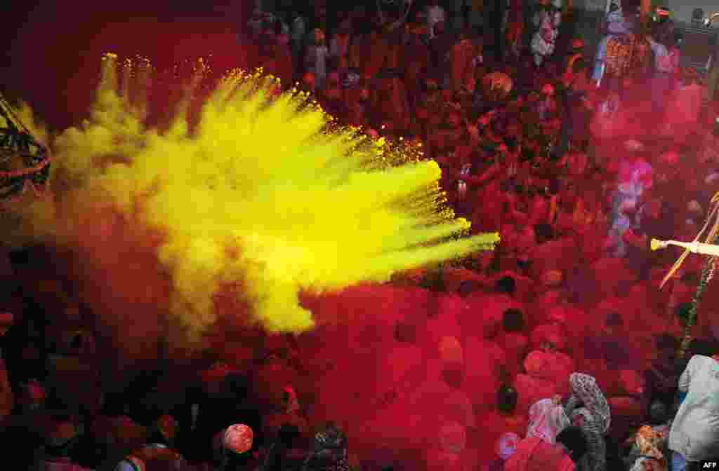 Umat Hindu India membuang bubuk berwarna di kuil Radha Rani selama festival Lathmar Holi di Barsana, India.
