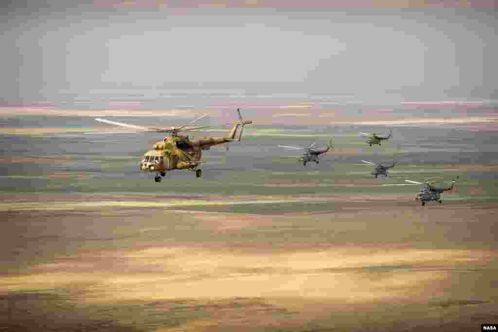 Beberapa helikopter penyelamat Rusia terbang di atas Kazakhstan dari kota Karaganda ke Zhezkazgan, menjelang pendaratan pesawat ruang angkasa Rusia 'Soyuz' dari stasiun antariksa internasional (ISS).