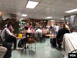 Pasajeros esperan sus vuelos en la sala de embarque del aeropuerto Toussaint Louverture de Puerto Príncipe. (S. Lemaire / VOA)