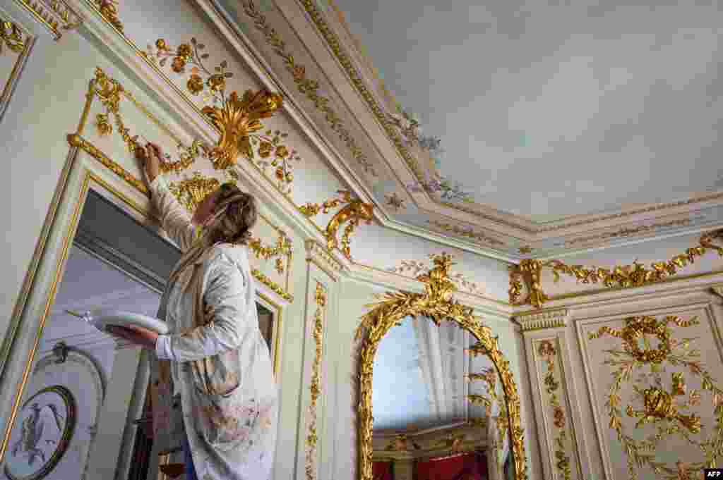 A painter adds finishing touches to ornamental decoration inside the "Villa La Grange" where U.S. President Joe Biden and Russian President Vladimir Putin are scheduled to meet June 16, in Geneva.