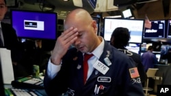 FILE - Specialist Mario Picone works on the floor of the New York Stock Exchange, Aug. 14, 2019. The Dow Jones industrial average sank 800 points that day after the bond market flashed a warning sign about a possible recession.