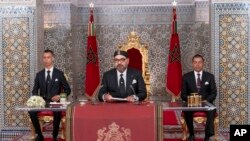 Mfalme wa Morocco Mohammed VI, katikati, akiwa na mtoto wake Moulay Hassan, kushoto, na kaka Prince Moulay Rashid akihutubia Taifa katika hotuba iliyoonyeshwa kwenye TV, kwenye Ikulu ya Kifalme huko Tetouan, Morocco, Jumatatu Julai 29, 2019.
