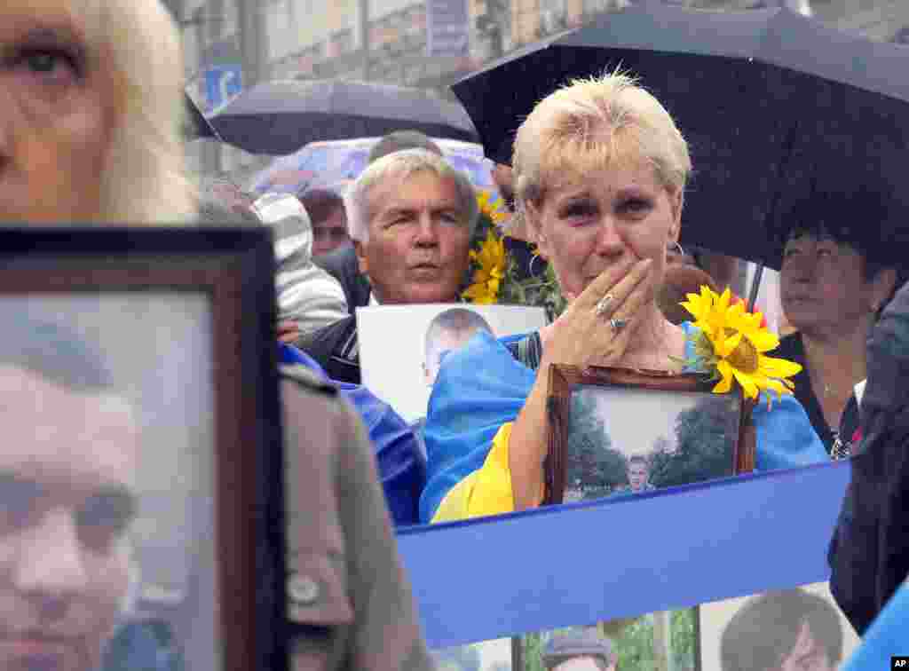 People hold photos of their relatives, who were killed in the conflict with pro-Russian separatists in the country's east, as they attend a rally for Independence Day in the Ukrainian capital Kyiv.