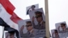 FILE - Posters of Army Chief General Abdel Fattah al-Sisi are seen as supporters of the army protest against ousted Islamist President Mohamed Morsi.