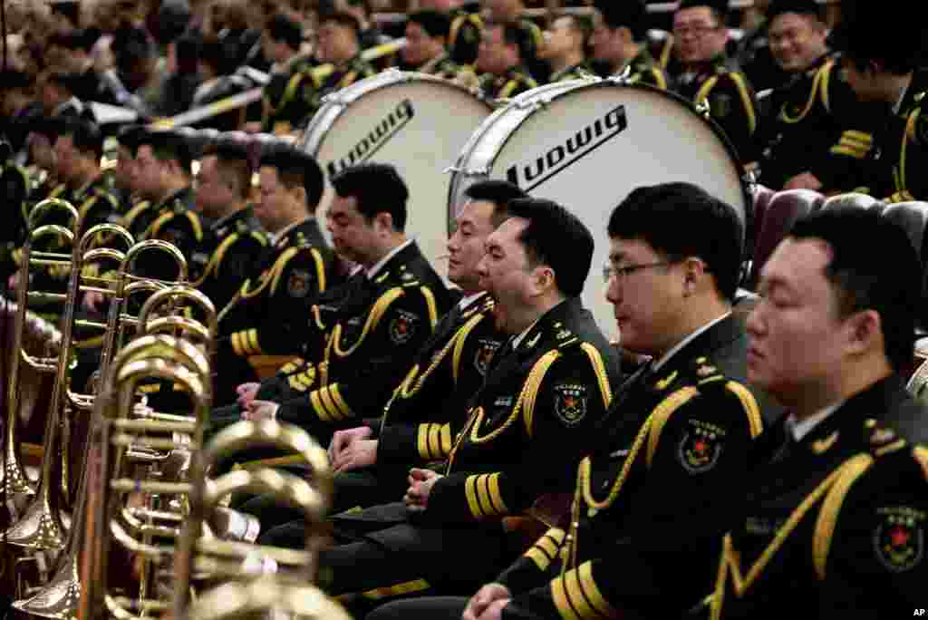 Seorang anggota band militer menguap sementara yang lainnya mendengarkan pidato Perdana Menteri Wen Jiabao pada Kongres Nasional Rakyat China di Beijing (5/3). (AP/Andy Wong)