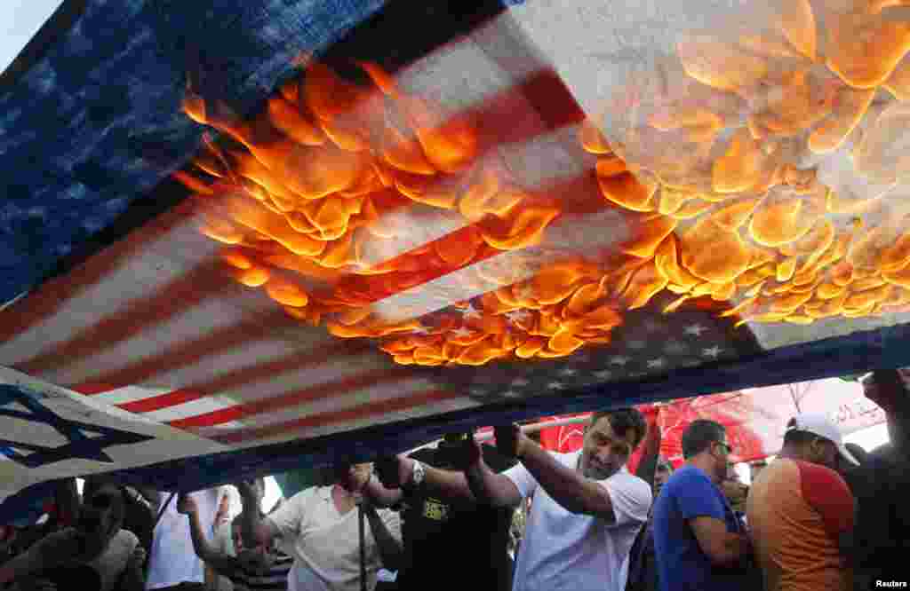 Para demonstran di Sidon, Lebanon melakukan unjuk rasa membakar bendera AS dan Israel.