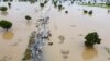 FILE - People walk through floodwaters after heavy rainfall in Hadeja, Nigeria, Monday, Sept 19, 2022.