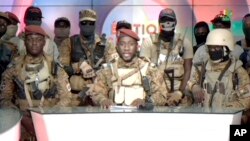 In this image from state TV, army Capt. Kiswendsida Farouk Azaria Sorgho reads a statement in Ougadougou, Burkina Faso, Sept. 30, 2022. Members of Burkina Faso's army declared late Friday that the country's leader, Lt. Col. Paul Henri Damiba, had been overthrown.