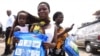 FILE - A woman carrying a baby holds a treated mosquito net during a malaria prevention action at Ajah in Eti Osa East district of Lagos, Nigeria, April 21, 2016.