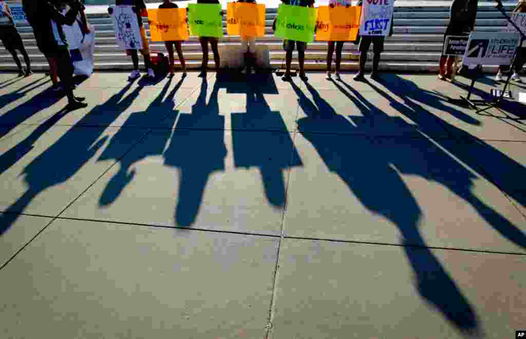 Protesters' shadows are cast outside the Supreme Court.