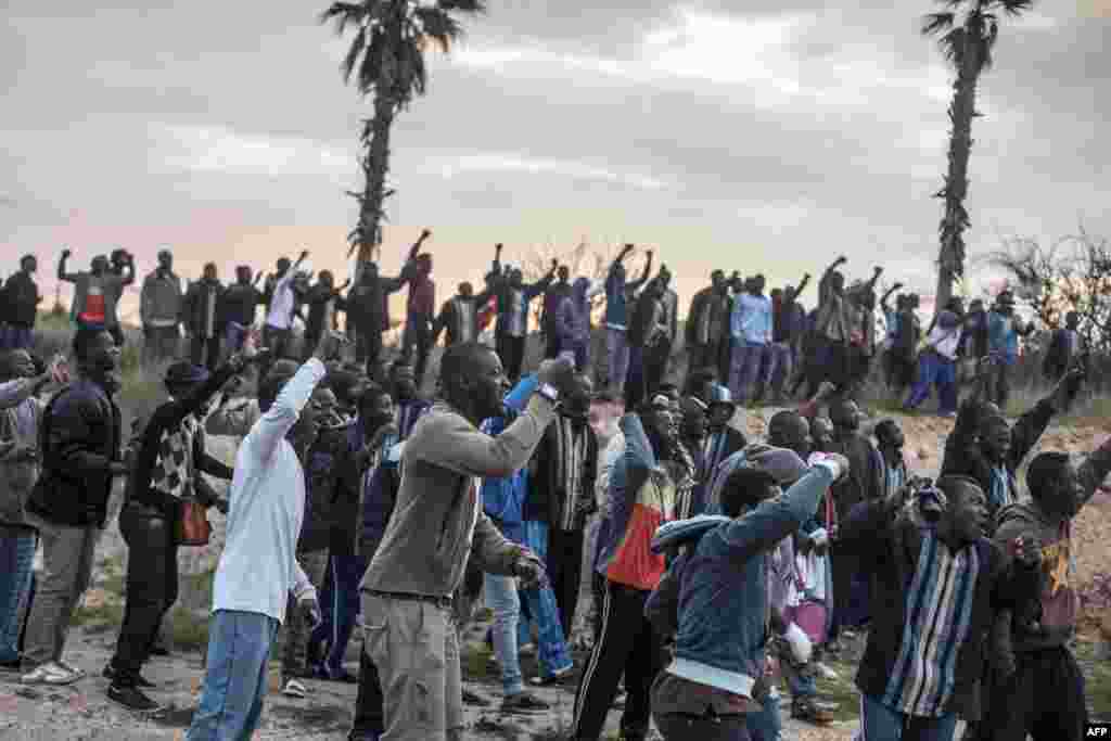Para calon imigran dari Pusat Penampungan Sementara Imigran (CETI) bersorak menyemangati mereka yang akan menyeberangi pagar dekat Beni Enza, menuju wilayah utara kantong Spanyol Afrika di Melilla. Beberapa ratus orang mencoba untuk menyeberang menuju kota Spanyol itu, yang terletak di ujung utara Maroko. 