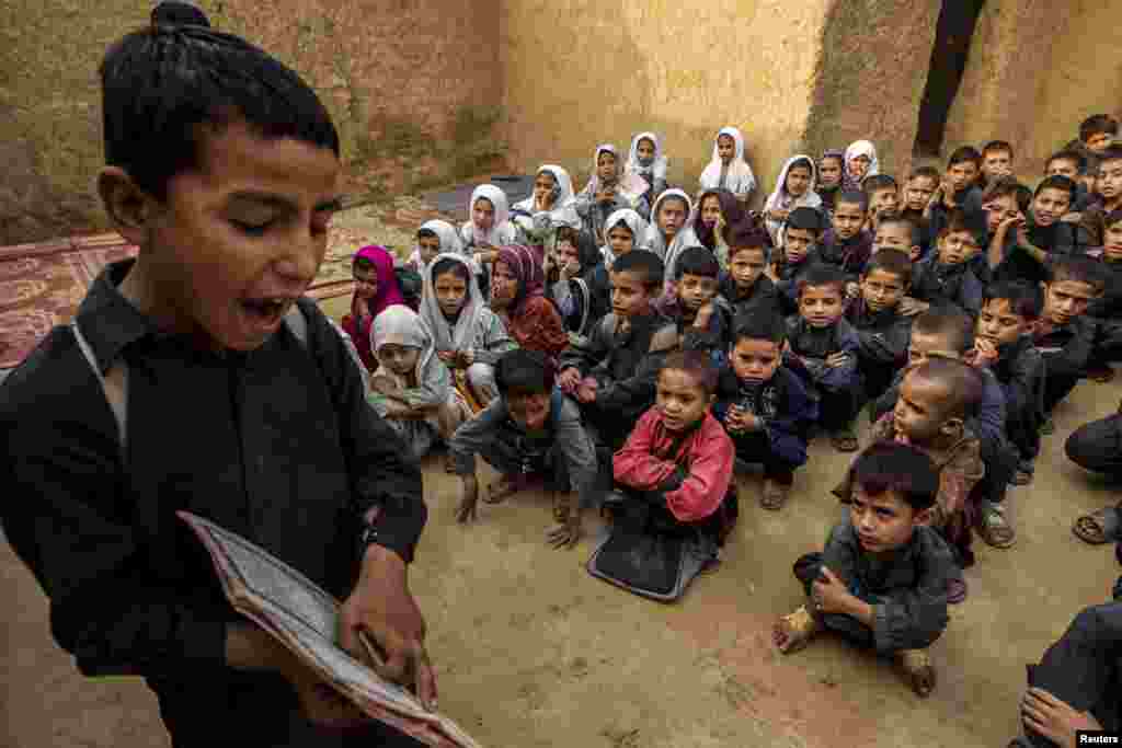 Seorang anak laki-laki membaca bukunya saat jam pelajaran di sebuah sekolah di perkampungan kumuh di pinggiran kota Islamabad, Pakistan.