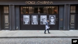 Čovjek sa maskom prolazi pored zatvorene prodavnice u četvrti Soho u Njujorku (Foto: AP)