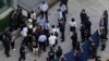 Investors are surrounded by police and security personnel as they try to enter the headquarters of the real estate developer Evergrande Group, Sept. 23, 2021, in Shenzhen, China. 