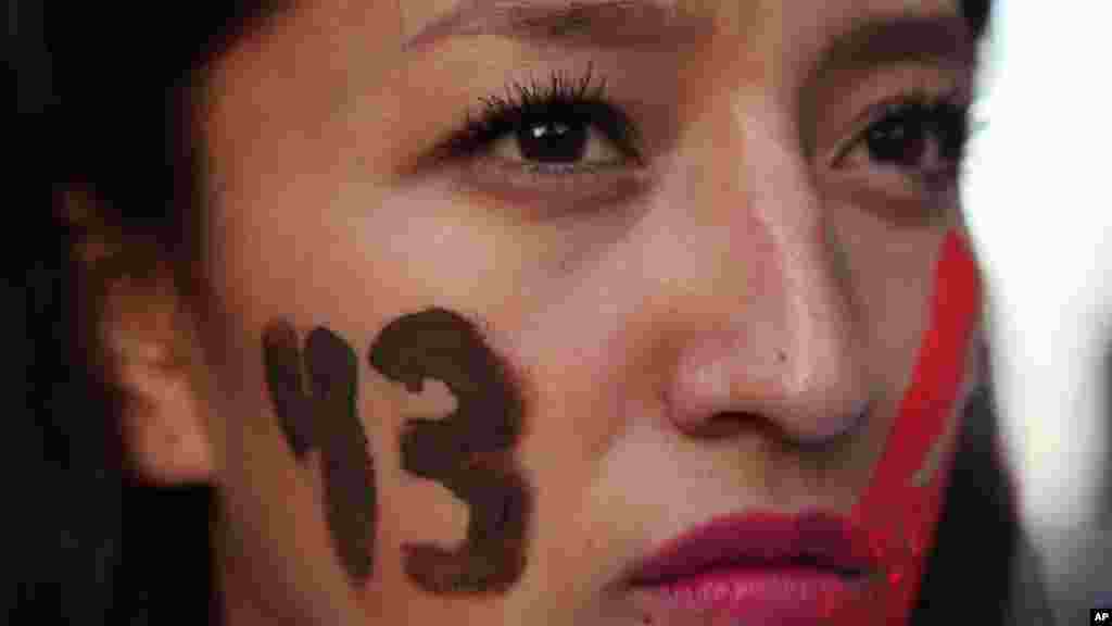 Seorang demonstran perempuan menuliskan angka 43 di pipinya, atau jumlah mahasiswa negara bagian Guerrero yang masih hilang, dalam protes di Mexico City (5/11). (AP/Marco Ugarte)