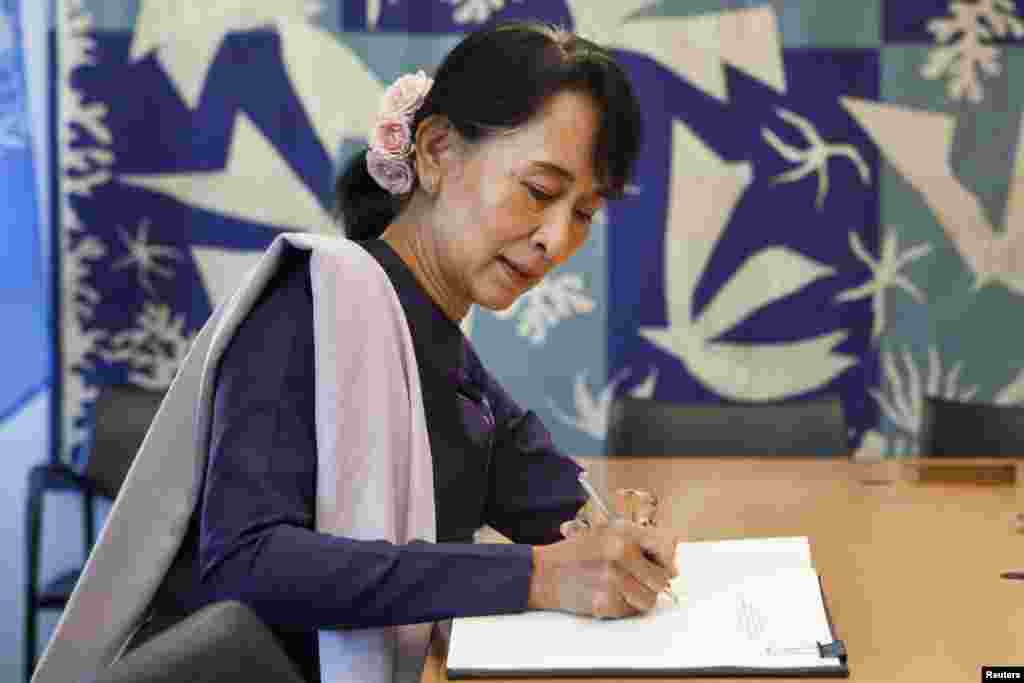 Bà Suu Kyi ký sổ dành cho khách đến gặp Tổng thư ký Liên Hiệp Quốc Ban Ki-moon tại New York, 21/9/2012.