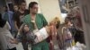 A doctor carries a severely wounded Syrian boy in the Dar El Shifa hospital, in Aleppo, Syria, Oct. 4, 2012 after the child was hit by Syrian Army shelling. 