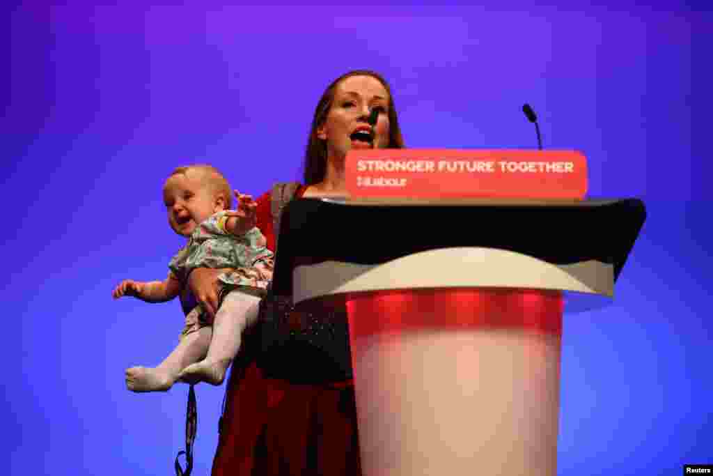 Delegate Catherine Atkinson speaks as she carries her 9-month-old Elena, during Britain's Labor Party annual conference in Brighton, Britain.